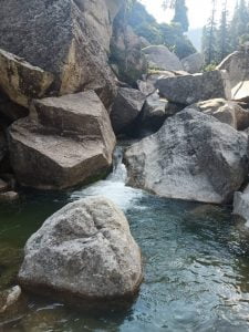 Stream flowing through large granite boulders in the Himalayas near Dharamsala