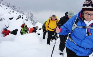 Trekkers crossing snow-covered trail to Indrahar Pass in Himachal Pradesh