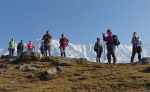 Group of trekkers at Triund with snow-covered Dhauladhar mountains in background