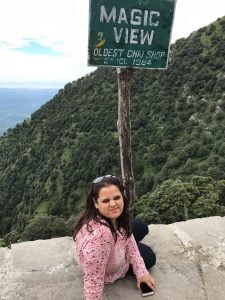 a woman sitting on a ledge with a sign on the side