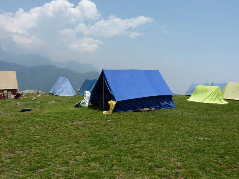 a group of tents on a grassy hill