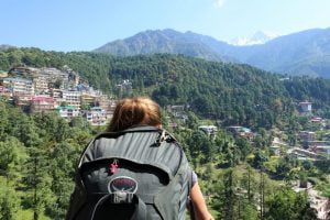 Backpacker overlooking McLeod Ganj and the Dhauladhar mountains in Dharamshala