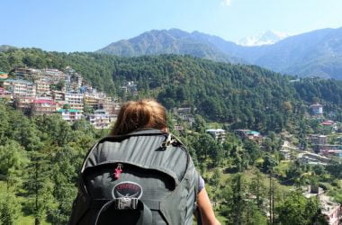 Backpacker overlooking McLeod Ganj and the Dhauladhar mountains in Dharamshala