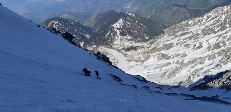people climbing a mountain with snow