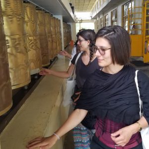 Tourists spinning traditional Tibetan prayer wheels at a monastery in McLeod Ganj, Dharamshala
