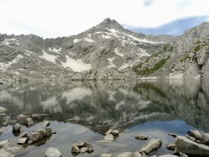 Nag Dal Lake with rocky Himalayan peaks and reflections in the clear alpine water