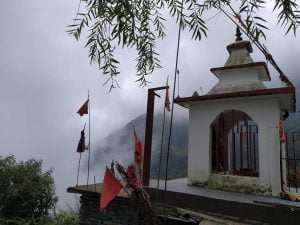 Leta Wali Mata Temple surrounded by misty mountains and red flags in Dharamshala, Himachal Pradesh