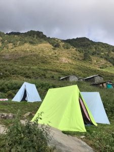 Camping tents at Leta Camp surrounded by lush green hills on Laka Glacier Trek