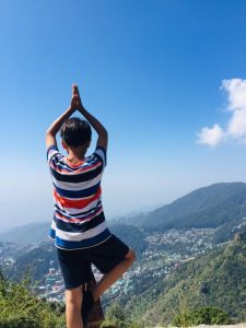 Man doing yoga pose with Himalayan view during Laka Glacier Trek